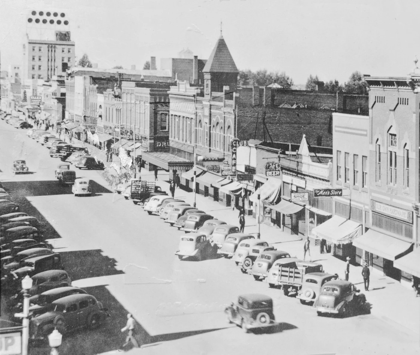 Historic view west along Bozeman Main Street with storefronts and parked automobiles